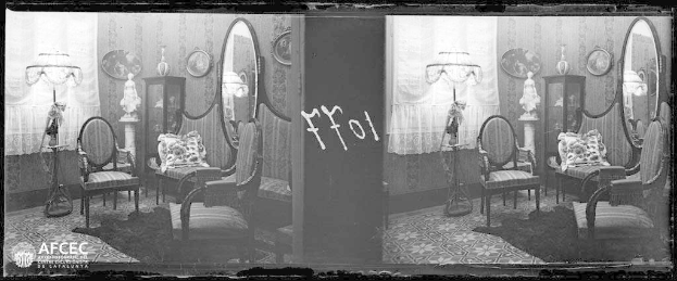 Schwarz-weiß-Foto eines möblierten Zimmers mit Stühlen, Kissen, Lampen, Schränken, Spiegeln, Vorhängen und anderen Gegenständen, mit einem vintage-Wasserzeichen.