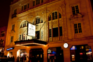 Ein gelbes Gebäude mit Geschäften im Erdgeschoss, von denen eines ein weißes Schild mit der Aufschrift 'Metro' hat.