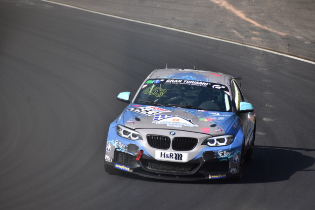 Ein BMW M2 GT3 Rennwagen auf einer Rennstrecke, mit Text und Zahlen auf seiner Karosserie.