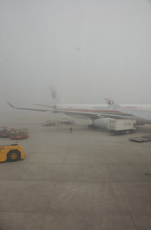 Flugzeug und Fahrzeuge auf einer Start- und Landebahn.