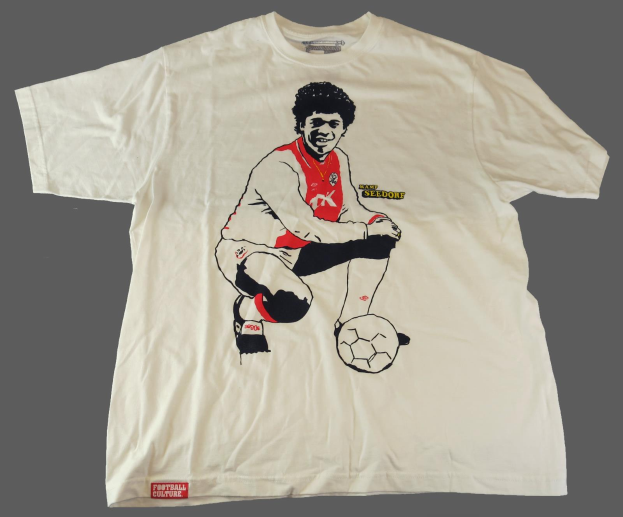 Ein weißes T-Shirt mit einer Zeichnung eines Fußballspielers, Marcelo, der auf einem Ball sitzt, vor einem grauen Hintergrund.