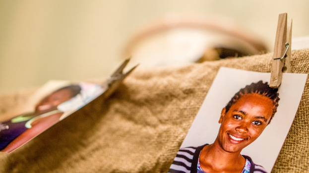 Auf einem Tisch liegt ein Büroklipp, ein passportgroßes Foto und ein Stoffstück auf der rechten Seite, mit einem unscharfen Hintergrund und linker Seite.