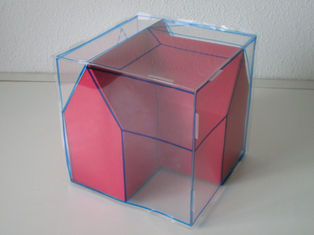 Ein pinker und blauer Wahlkasten mit offenem Deckel, der Papiere enthält, auf einem weißen Tisch gegen eine Wand gestellt.