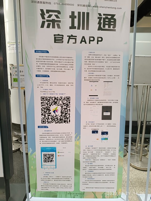 Ein Banner mit einem QR-Code vor einem Gebäude, wahrscheinlich beworben Shenzhen International Airport, umgeben von Ständen und anderen Gegenständen.