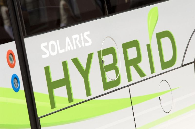 Nahaufnahme eines weißen und grünen Busses mit der Aufschrift "Solaris Hybrid".