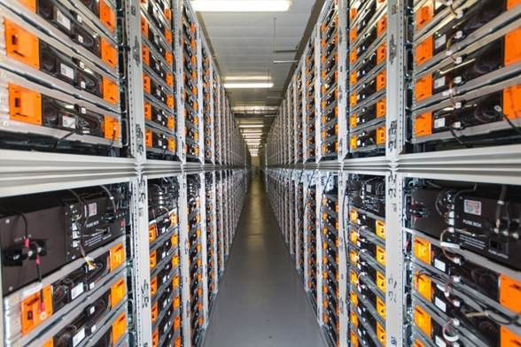 Eine lange Reihe von Servern in einem Rechenzentrum mit elektronischen Geräten in den Racks und Anzeigelichtern oben.