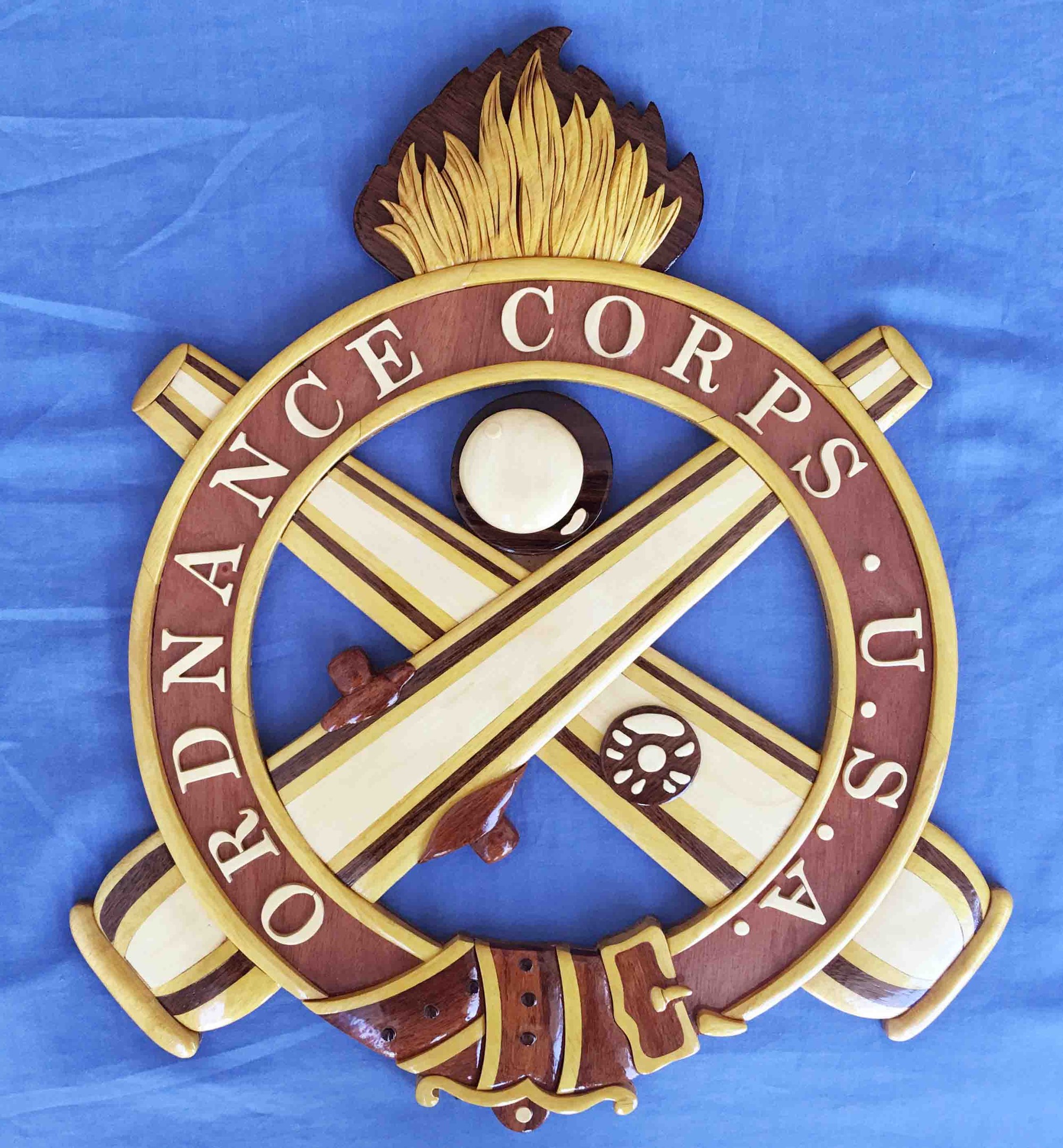 Holztafel mit "Ordnance Corps"-Text, mit einer geschnitzten navyblauen Hintergrund, weißer Stern und goldener Rahmen, auf blauem Tuch montiert.
