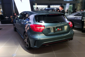 Ein Mercedes-Benz A-Klasse Hatchback auf der Internationalen Automobil-Ausstellung in Frankfurt, ein schlankes, modernes Design mit glänzender schwarzer Lackierung und Chromakzenten, umgeben von einer Gruppe von Menschen.