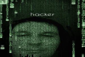 Das Gesicht eines Hackers auf einem Computerbildschirm mit dem Wort "Hacker" und darum herum binärer Code.