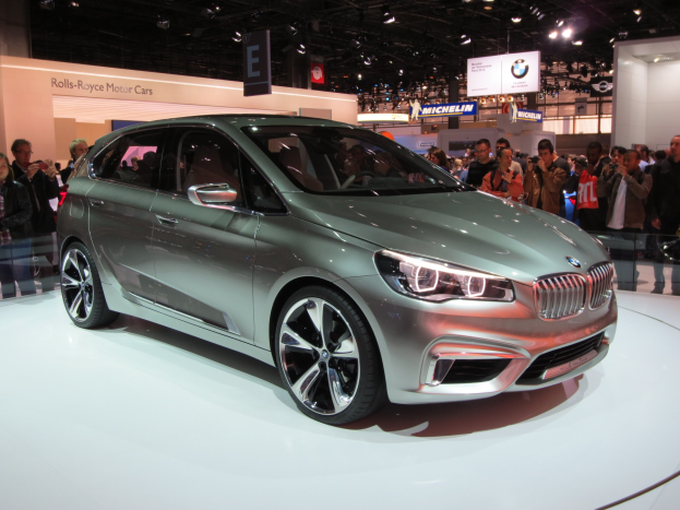 BMW 2er Active Tourer Concept auf der IAA in Frankfurt zu sehen, umgeben von Besuchern, die es fotografieren und Texttafeln im Hintergrund.