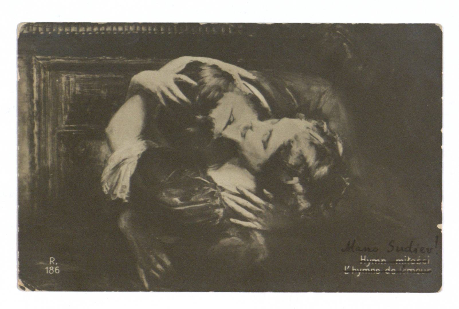 Schwarzes und weißes Foto eines Mannes in einem Anzug, der eine Frau leidenschaftlich küsst, die ihn umarmt, mit dem Text "L'hymne de l'amour" unten.