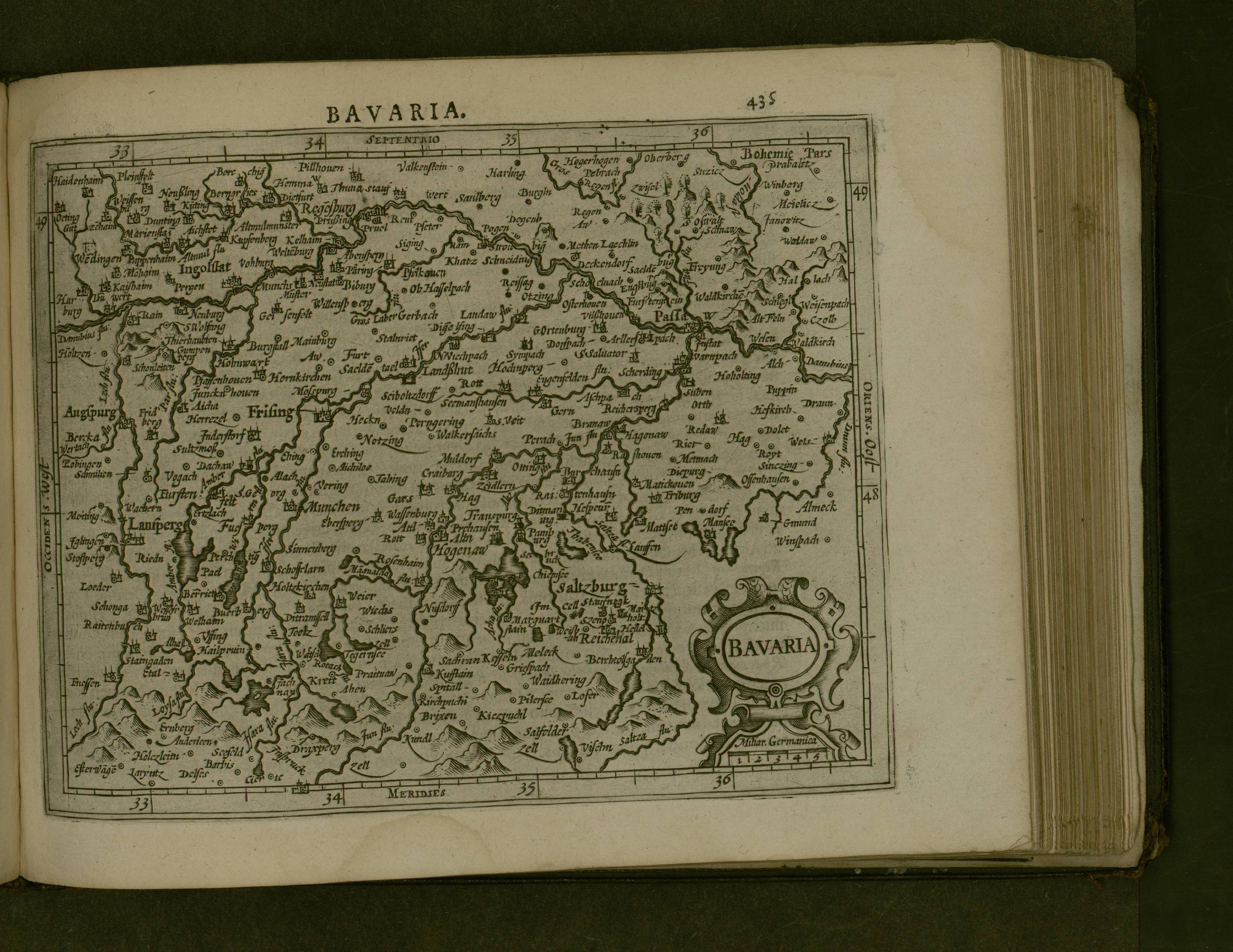 Offenes Buch mit einer detaillierten Karte von Bayern, einschließlich Städte und Ortschaften, mit angrenzendem Text, der wahrscheinlich die Region beschreibt.