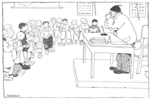 Ein Mann, mutmaßlich ein Lehrer, sitzt an einem Schreibtisch mit Büchern und Gegenständen vor einer Gruppe von Kindern, mit Papieren an der Wand hinter ihm.