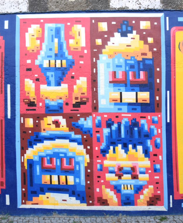 Ein buntes Wandgemälde an der Seite eines Gebäudes in Berlin, Deutschland, mit einer Vielzahl von Formen und leuchtenden Farben.